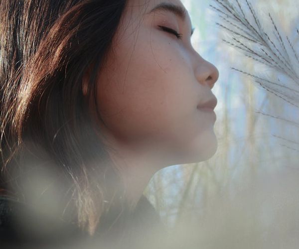 Profile of a woman with closed eyes, practicing deep conscious breathing.